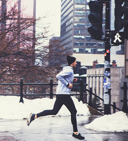 En man joggar i snön. 