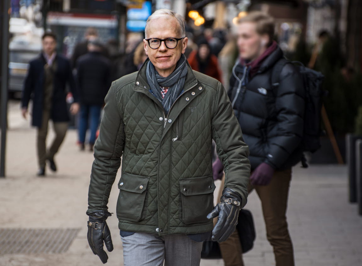 Sven Andreasson kommer gående längs en gata i stan. Han har på sig en tunn dunjacka och handskar och tittar in i kameran.