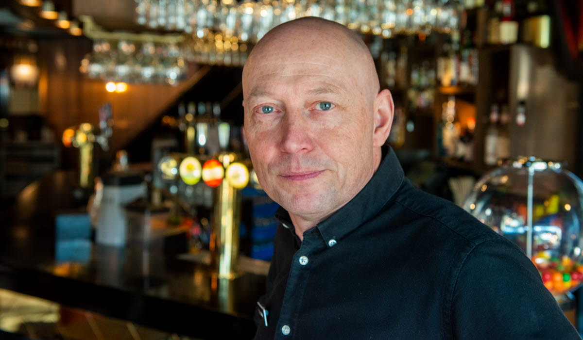 Christer Arnesson har på sig en skjort och sitter i en bar