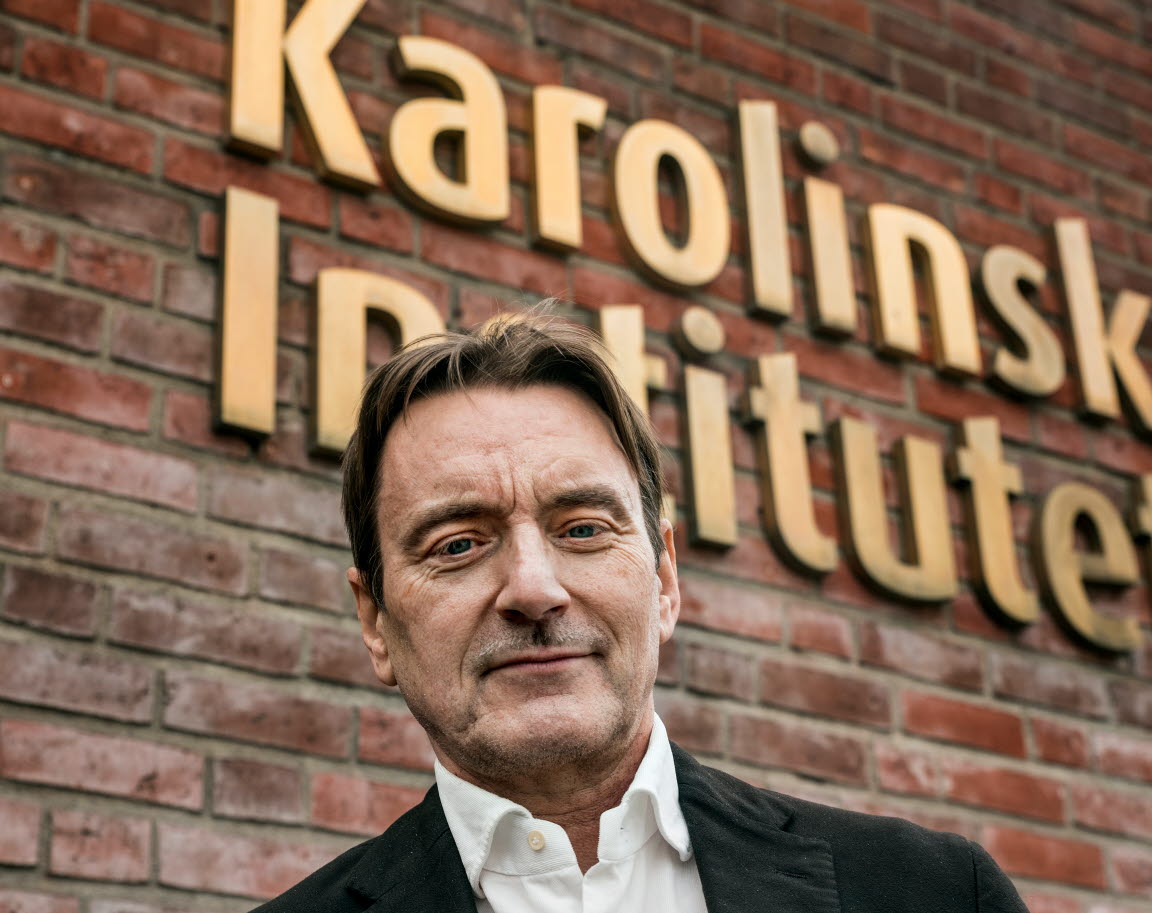 Johan Franck står framför en tegelvägg det det står "Karolinska institutet".