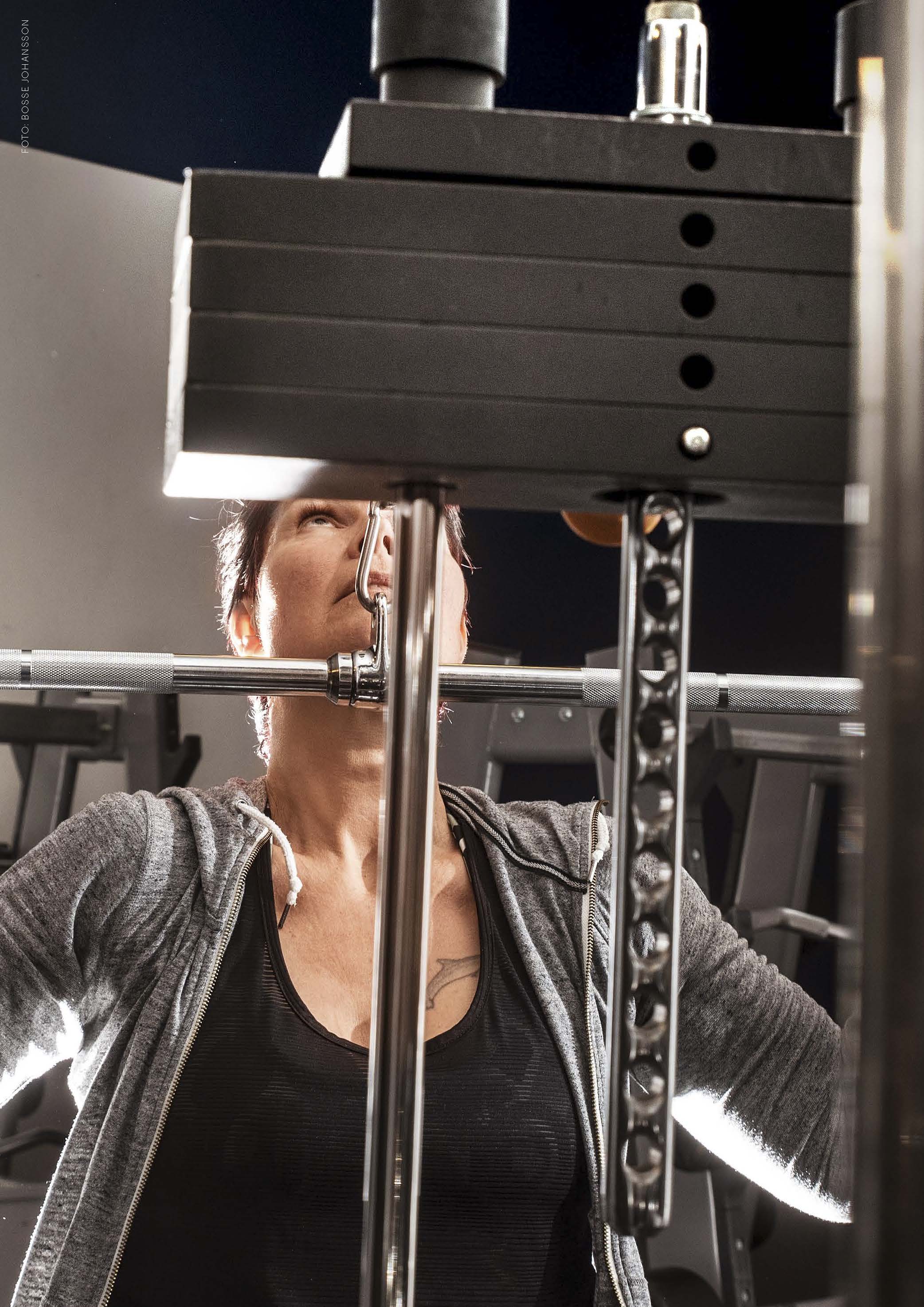 Närbild på Ulrika som befinner sig på ett gym där hon använder en träningsmaskin