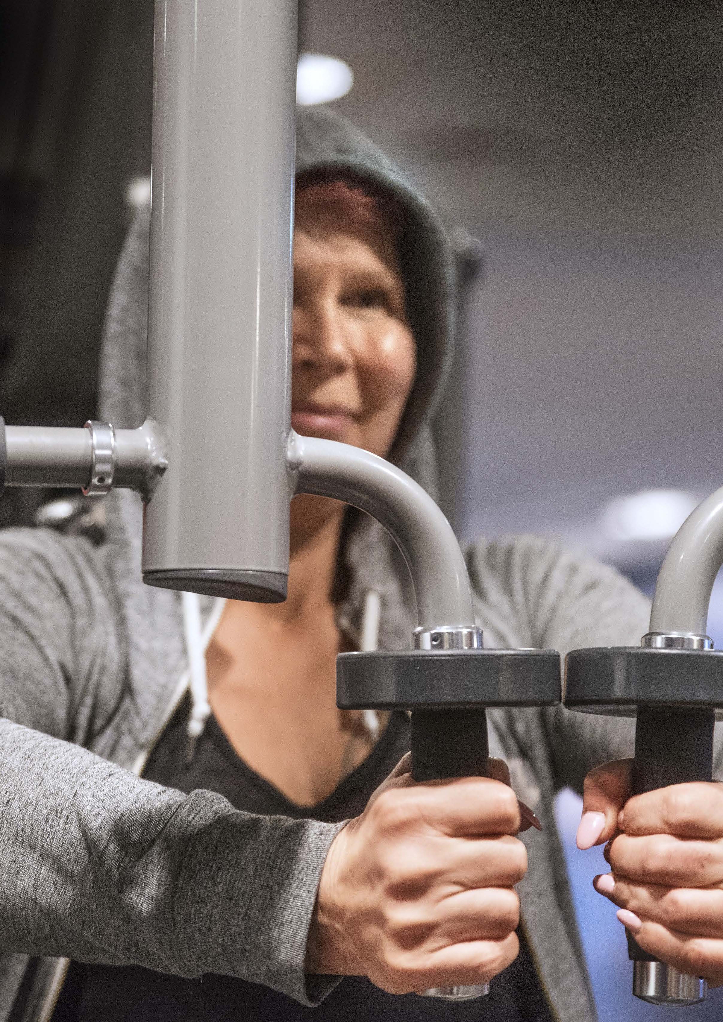 Närbild på Ulrika som befinner sig på ett gym där hon använder en träningsmaskin