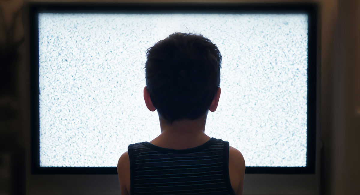Litet barn sitter ensam framför en TV där det bara visas statiskt brus. "Myrornas krig".