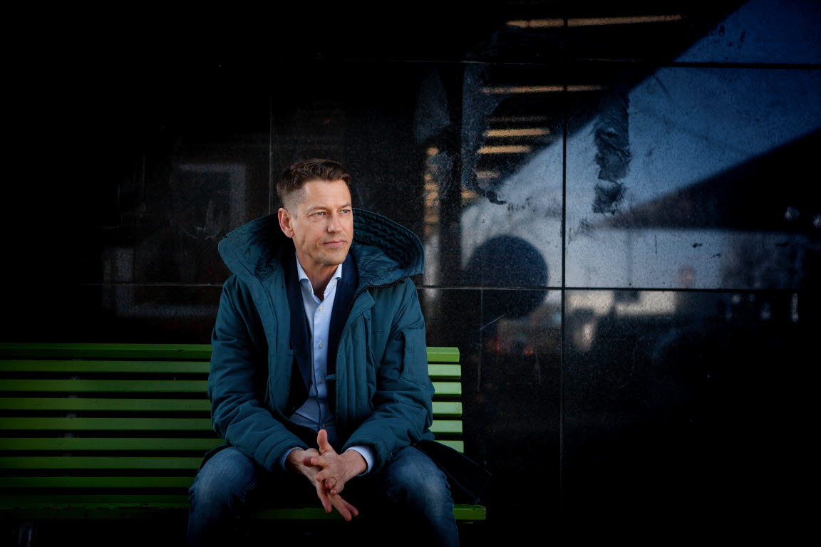 Magnus Jägerskog sitter på en bänk utomhus iförd en dunjacka. Han blickar till vänster om kameran